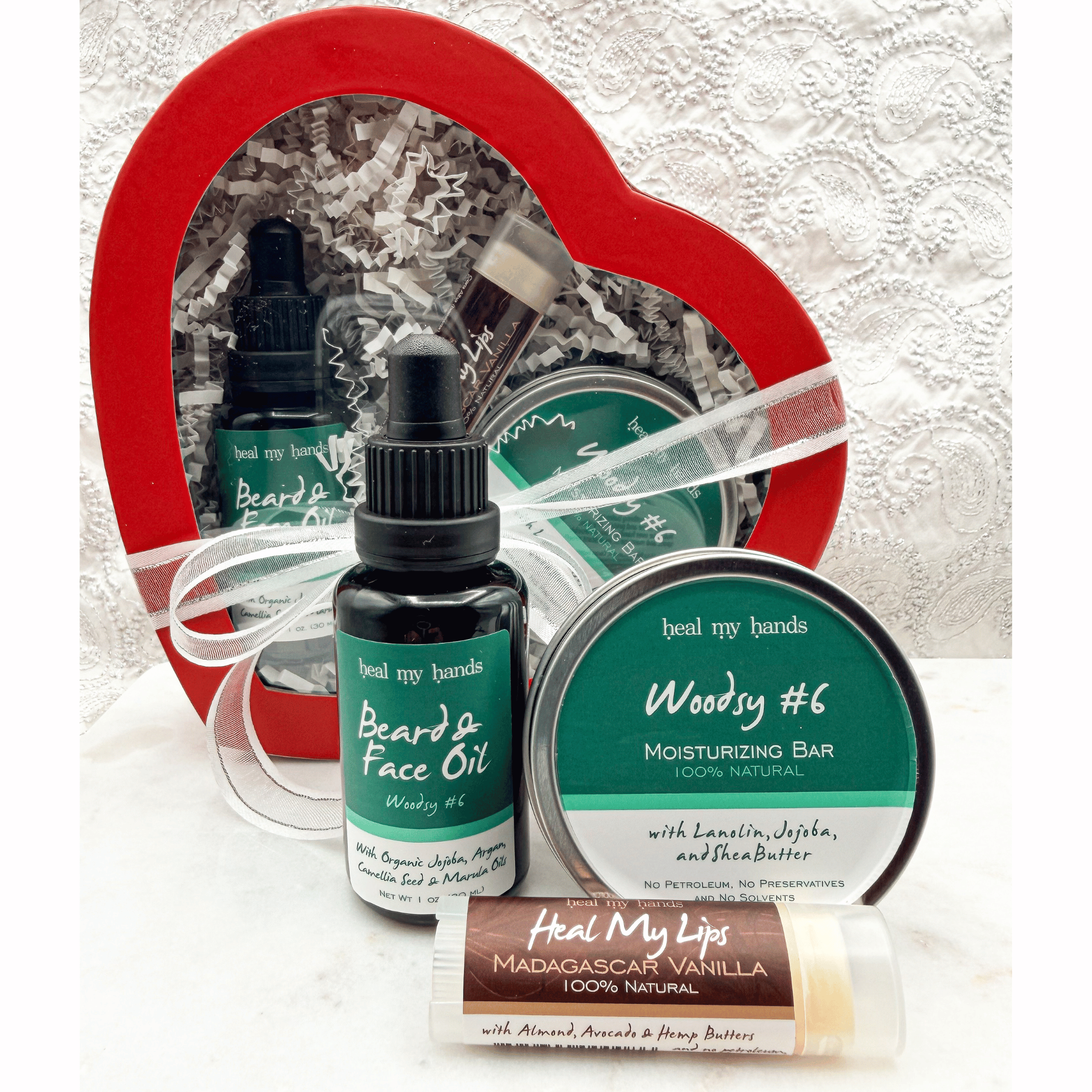 Collection of skincare products including a bottle, a bar, and a stick with a heart-shaped box in the background.