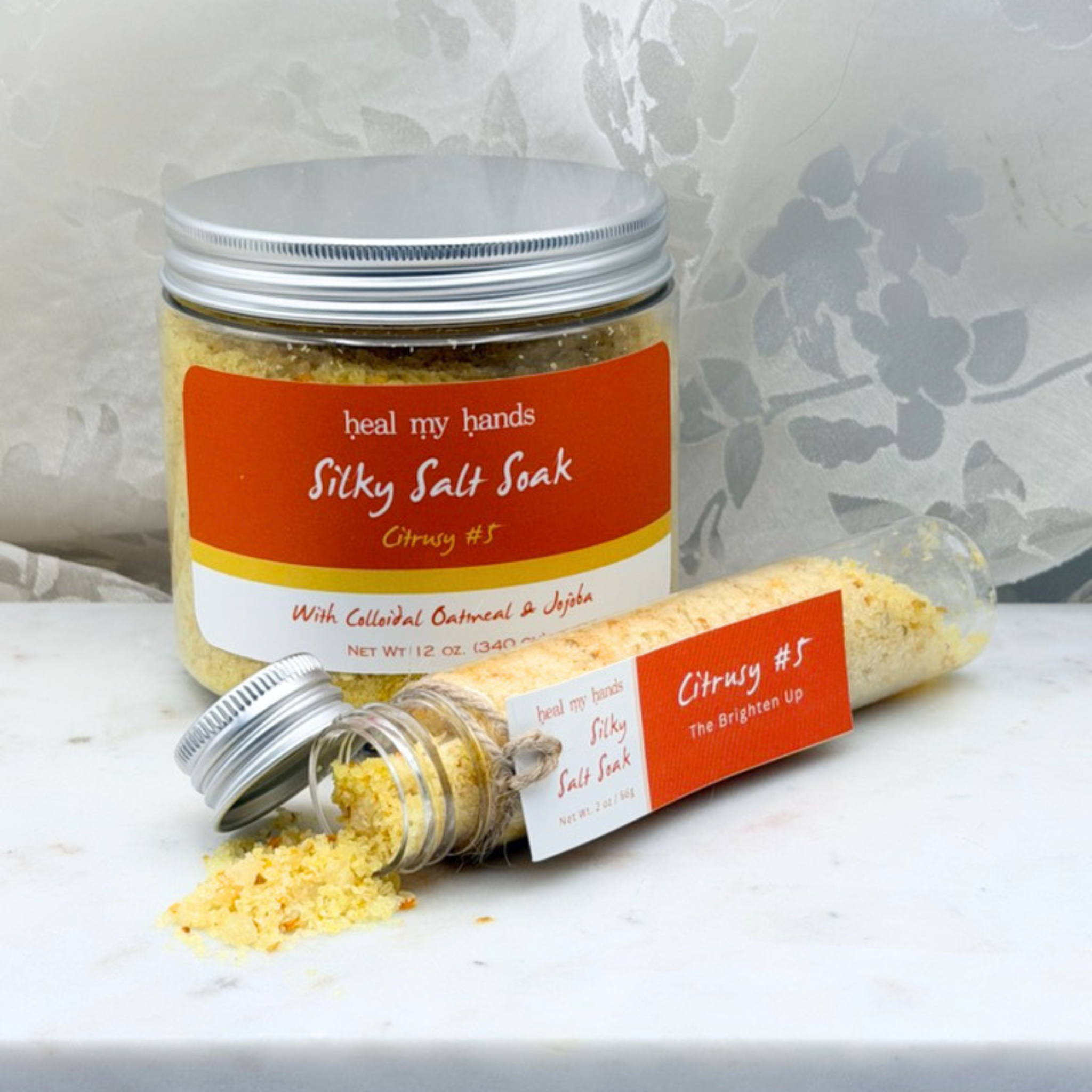 Citrusy #5 Silky Salt Soak 12 oz jar and 2 oz vial on marble surface.