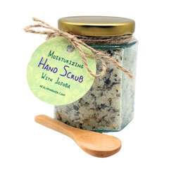 Jar of moisturizing hand scrub with a wooden spoon and label on a white background