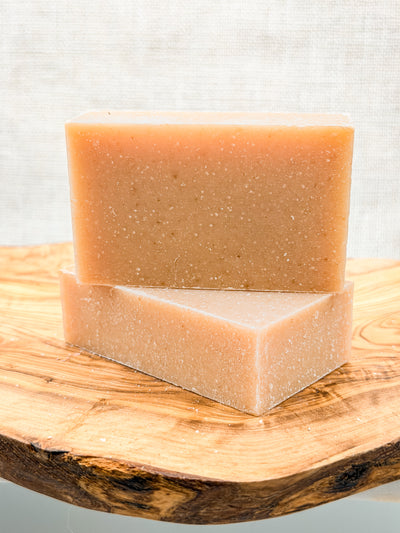 Two bars of soap on a wooden surface with a light background