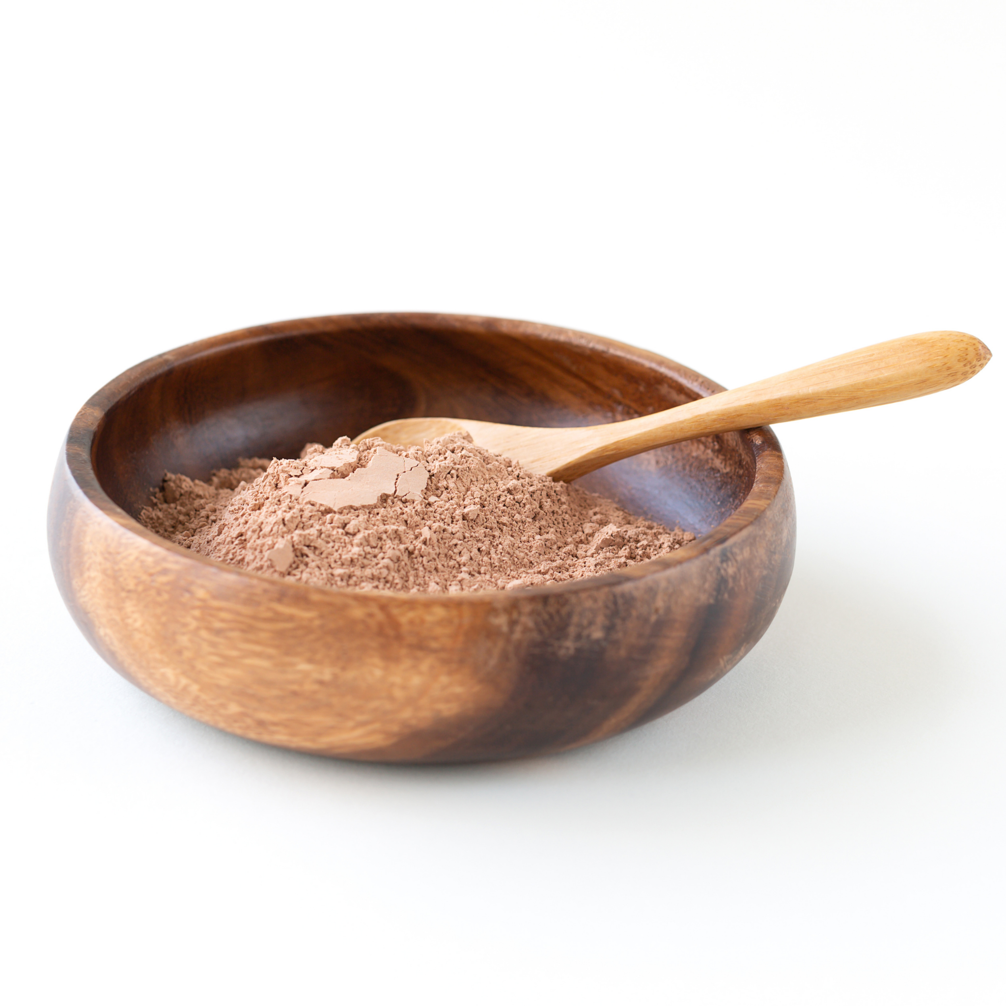 Wooden bowl with Rhassoul Clay powder and a wooden spoon on a white background