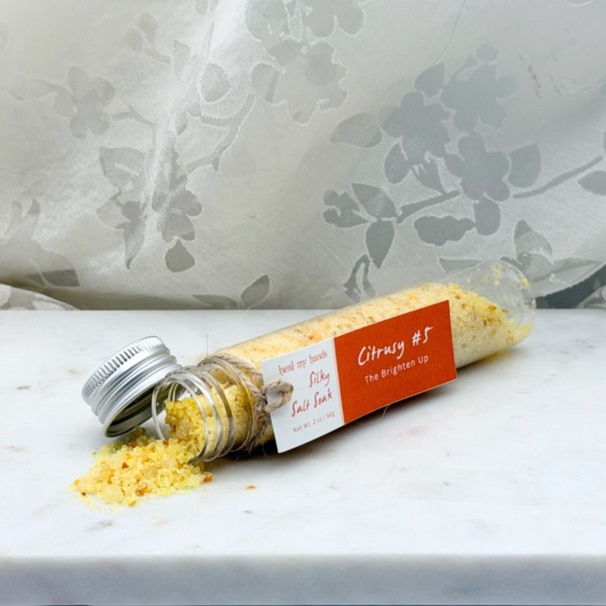 Citrusy #5 Silky Salt Soak 12 oz jar and 2 oz vial on marble surface.