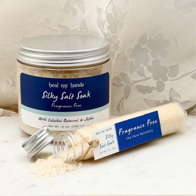 Fragrance Free Silky Salt Soak 12 oz jar and 2 oz vial on marble surface.