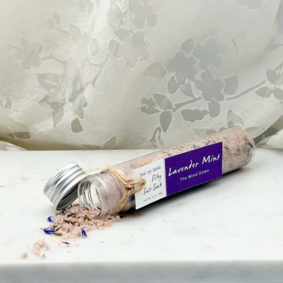 Lavender Mint Silky Salt Soak 12 oz jar and 2 oz vial on marble surface.