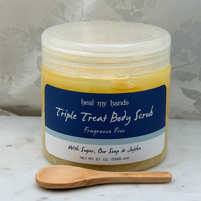 Fragrance Free Triple Treat Body Scrub jar and small wooden spoon on marble surface.