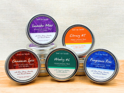Set of six tins with colorful labels on a wooden surface